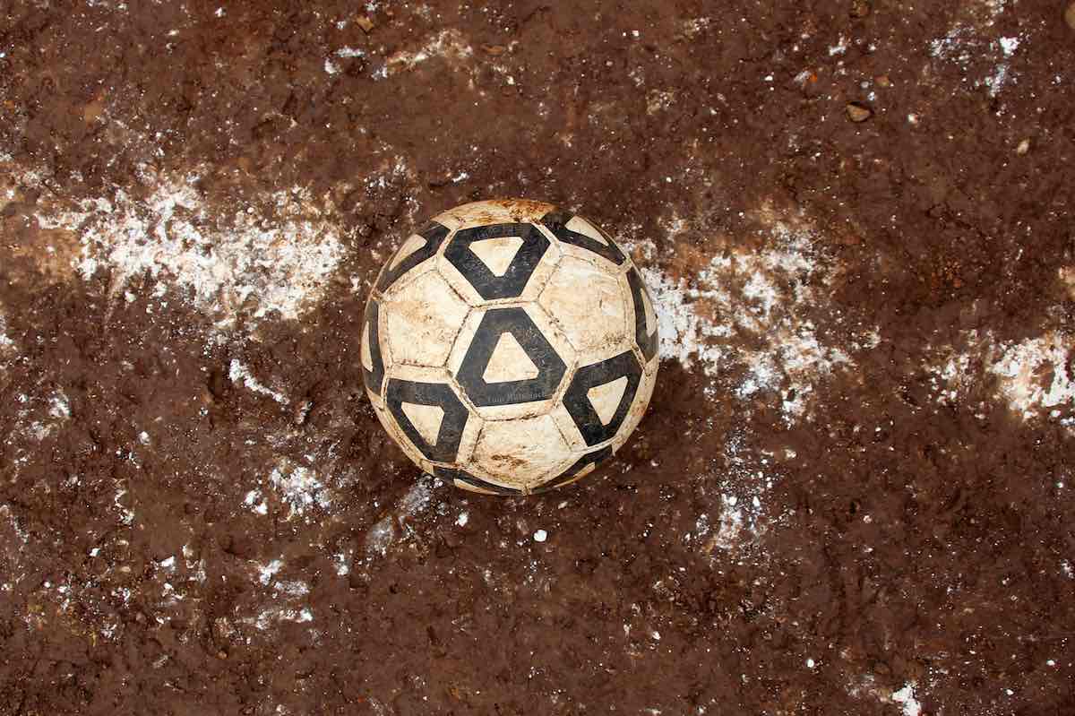 Ein Lederball liegt auf dem roten Hartplatz auf der Mittellinie.© Tom Rübenach
