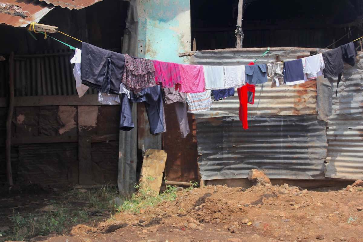 Blechhütte mit Kleidern zum Trocknen davor: Enge Lebensverhältnisse im Korogocho-Slum in Nairobi. Photo © Tom Rübenach
