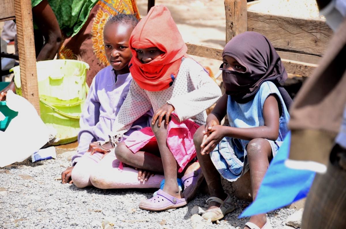 Auch ohne Masken schützen: Kinder ziehen sich Stoff über den kopf. Photo © Lucas Oduor